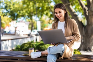 kvinna med laptop som jobbar utomhus