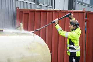 En medarbetare från Sanmix blästrar en metallyta